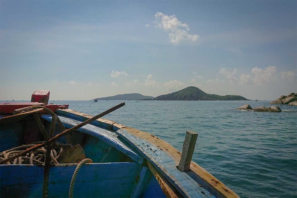Traditional wooden fishing boat used for Bai Xep island-hopping tours, sailing toward small islets off the Quy Nhon coast.