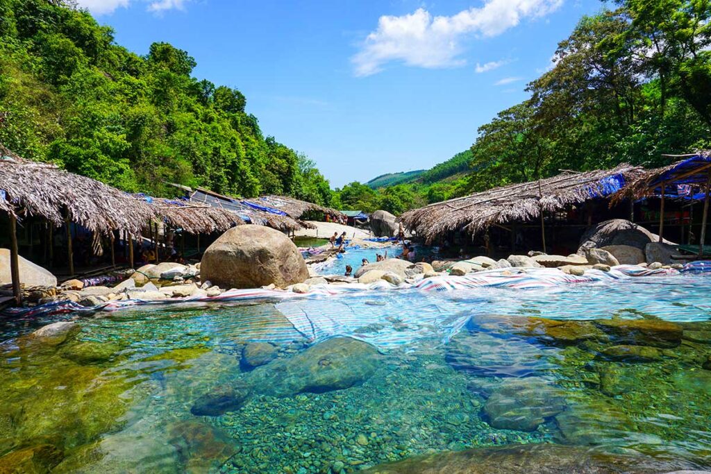 Series of mini waterfalls within jungle setting and small bamboo huts at the Elephant Spring in Hue