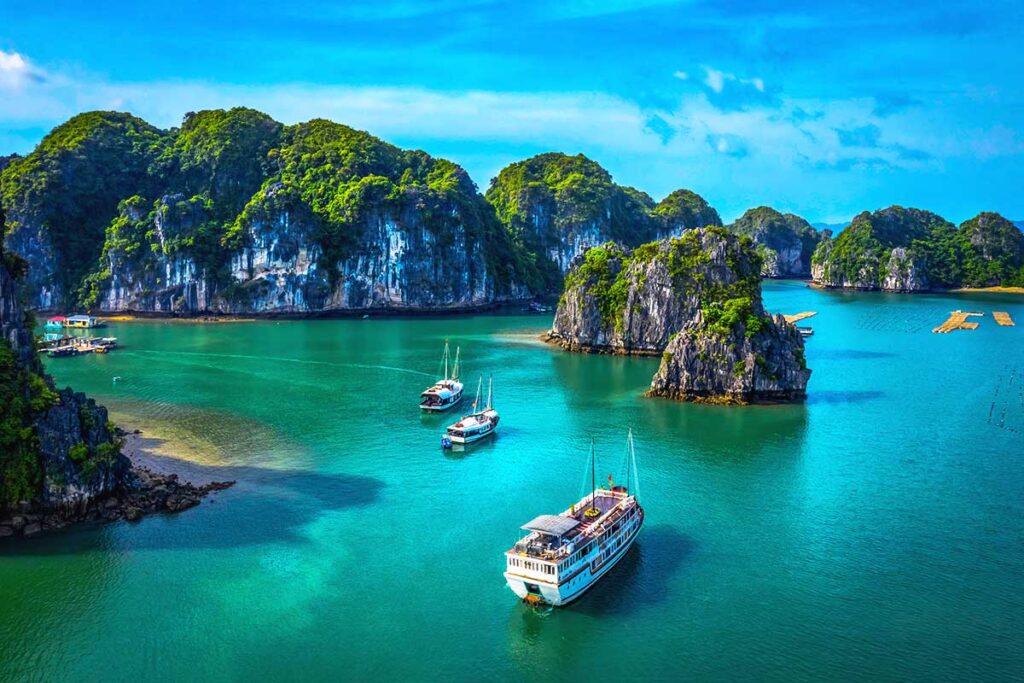 A cruise boat in Halong Bay passing islands and rocks, one of the best things to do in Vietnam.