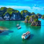 A cruise boat in Halong Bay passing islands and rocks, one of the best things to do in Vietnam.