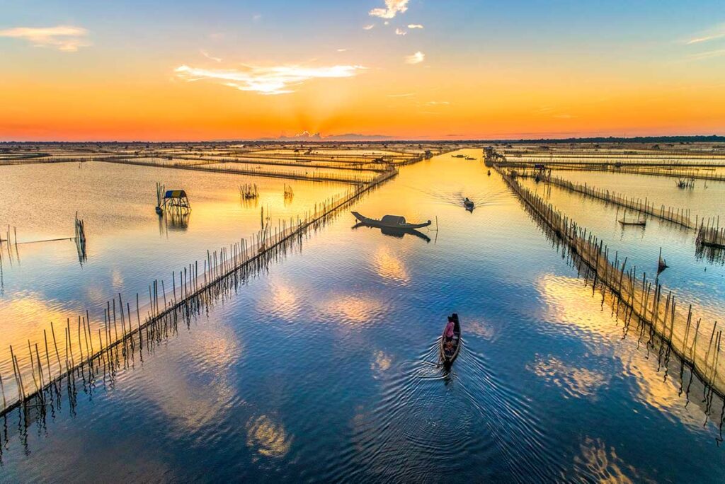 Small boats ride along barriers that are created for seafood and fish farming on Tam Giang Lagoon
