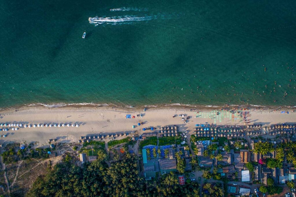 Aerial drone view of An Bang Beach showing turquoise sea, umbrellas, and coastal resorts in Hoi An
