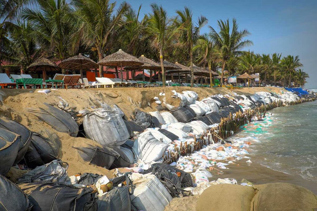 Coastal erosion barriers made of sandbags along Cua Dai Beach showing ongoing protection efforts