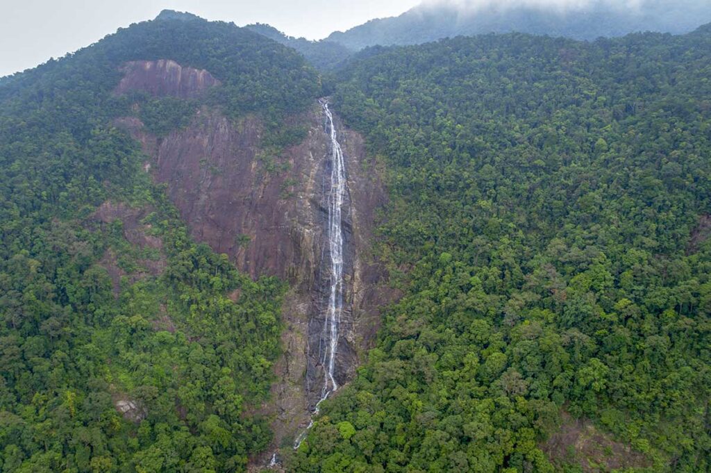 Aerial view of Do Quyen Waterfall thundering down from very high inside Bach Ma National Park