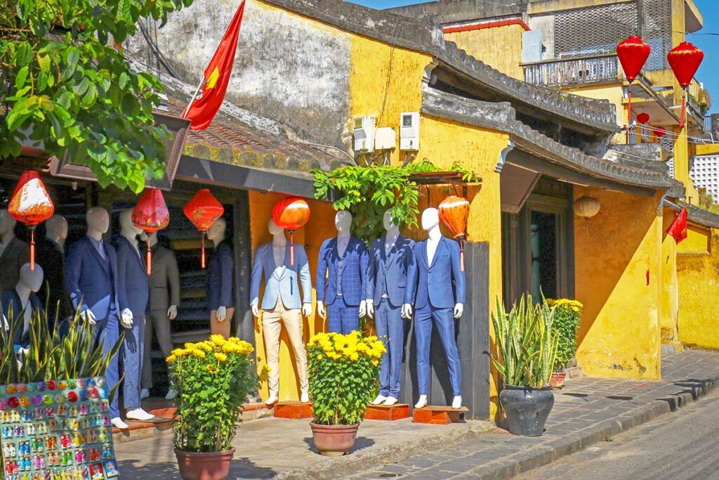 Tailor shop exterior in Hoi An displaying men’s suits, highlighting the town’s reputation for high-quality tailor made clothing.