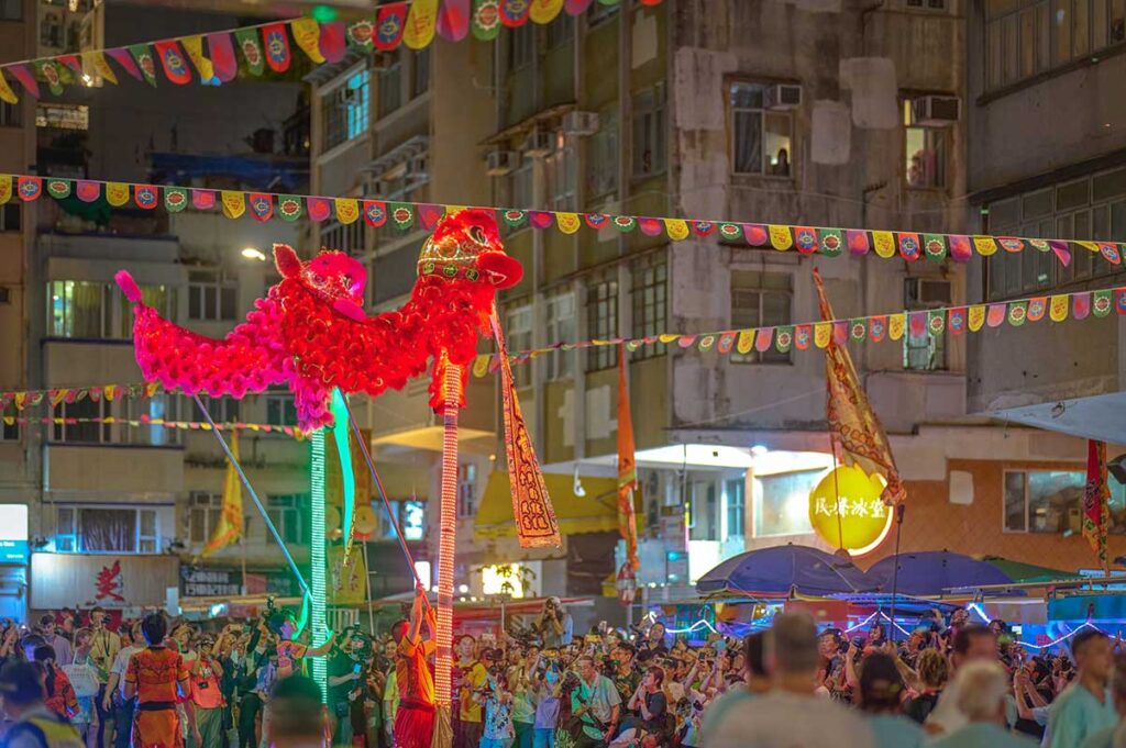 Many people are watching a lion dance performance in the streets of Hanoi during Mid Autumn Festival