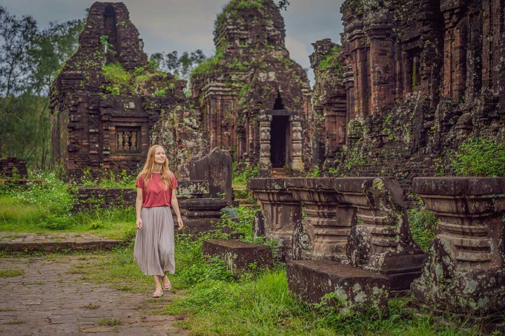 Traveler walking through the My Son Sanctuary ruins, highlighting the scale and quiet atmosphere of the ancient site.
