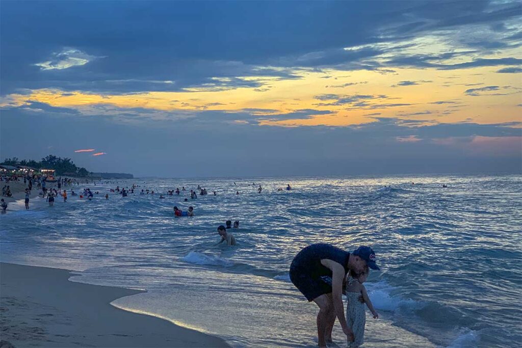The water at Thuan An Beach in Hue is full of locals after sunset