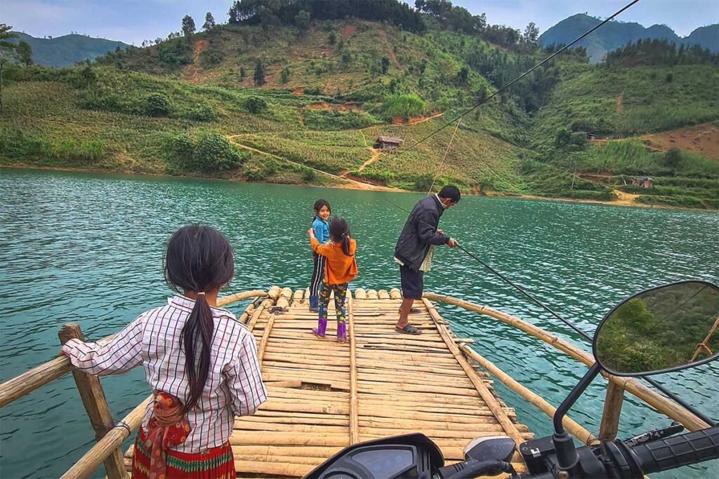 A bamboo ferry carrying people and a motorbike across the Nho Que River at Khau Vai in Ha Giang.
