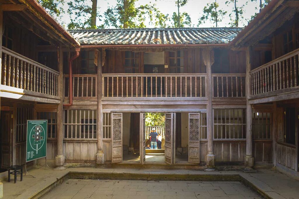 Inside the inner courtyard of the Hmong King Palace, surrounded by wooden walls and showcasing the historic architecture of the Hmong rulers.