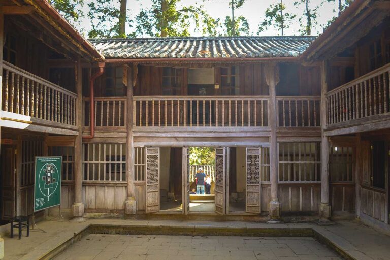 Inside the inner courtyard of the Hmong King Palace, surrounded by wooden walls and showcasing the historic architecture of the Hmong rulers.