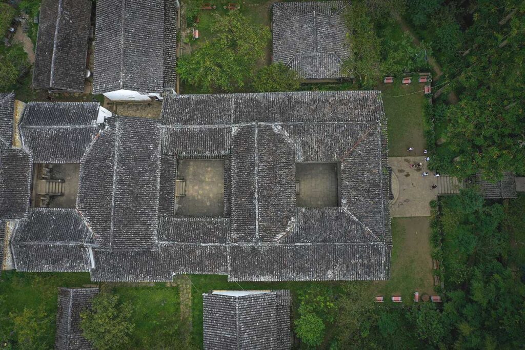 Aerial view of the Hmong King Palace, highlighting the tiled roof and the distinct three-courtyard layout of the historic complex.