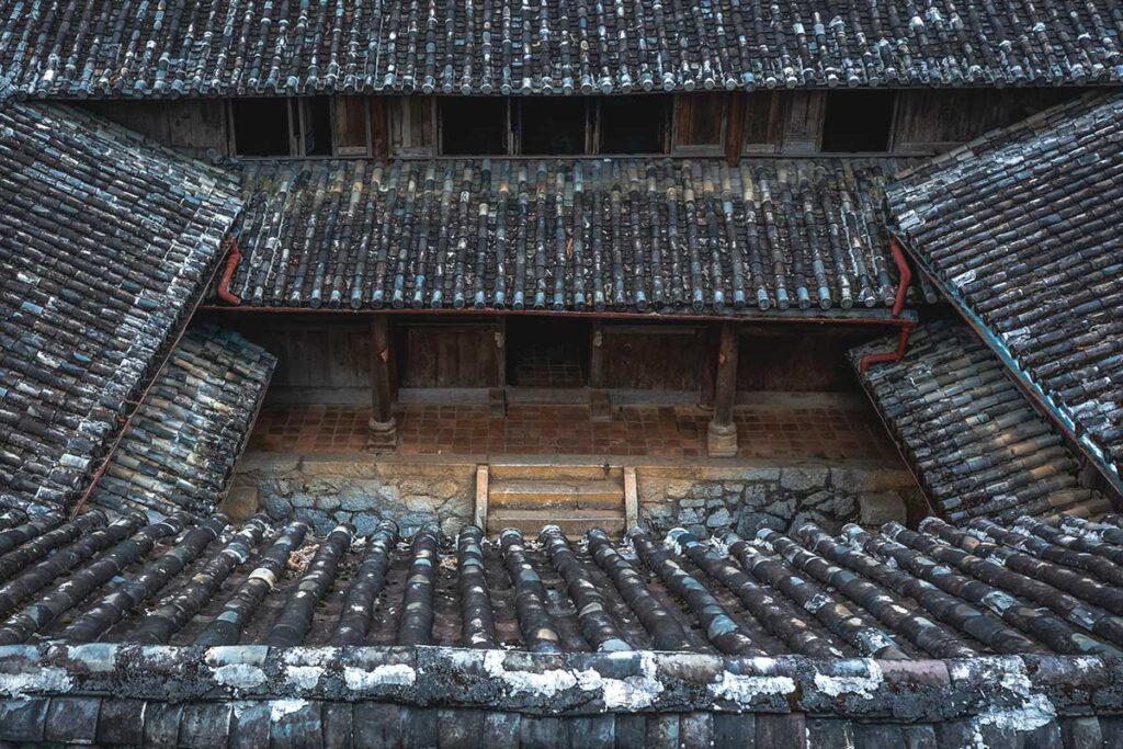 Close-up view of the tiled roofs of the Hmong King Palace, taken from above one of the courtyards, showcasing the intricate roofing design.
