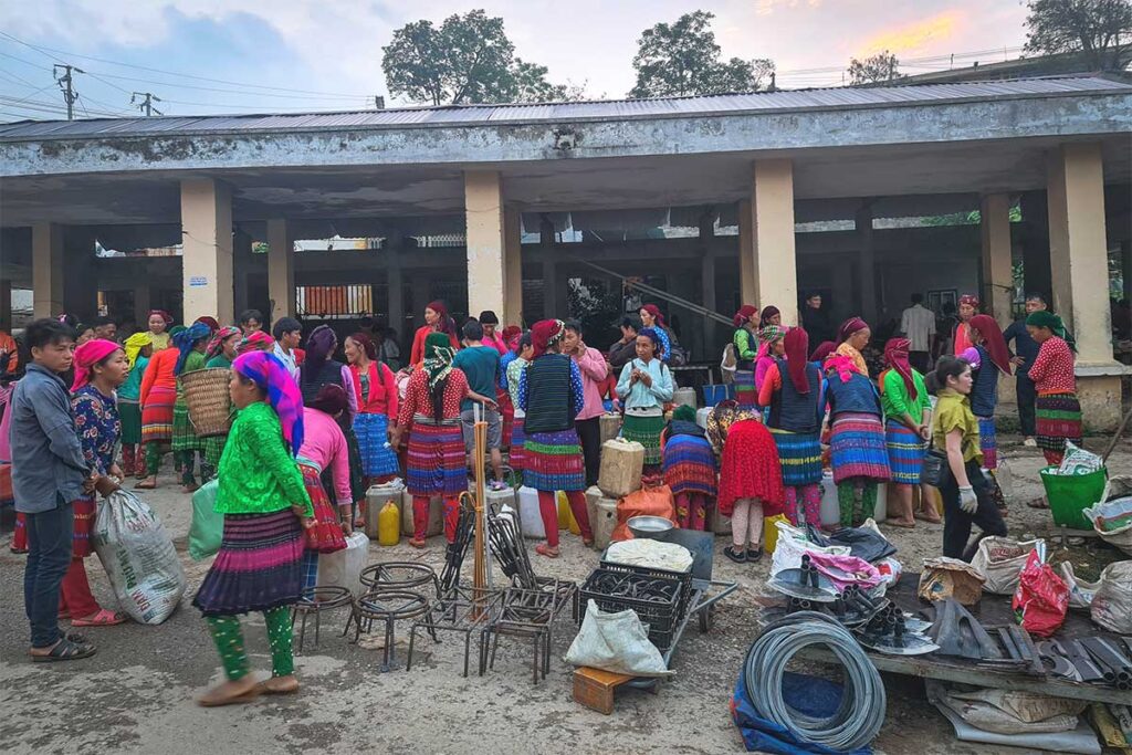 A bustling local market in Khau Vai, filled with colorful ethnic minorities selling and trading goods.