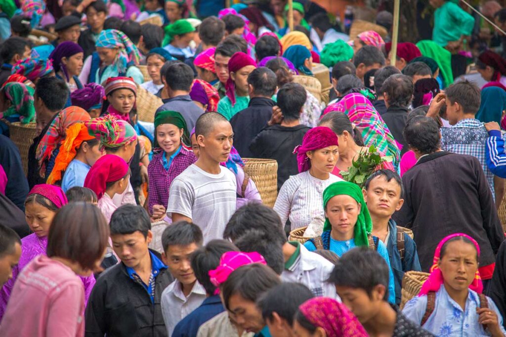 A large crowd of ethnic people dressed in vibrant traditional outfits at Meo Vac Market.