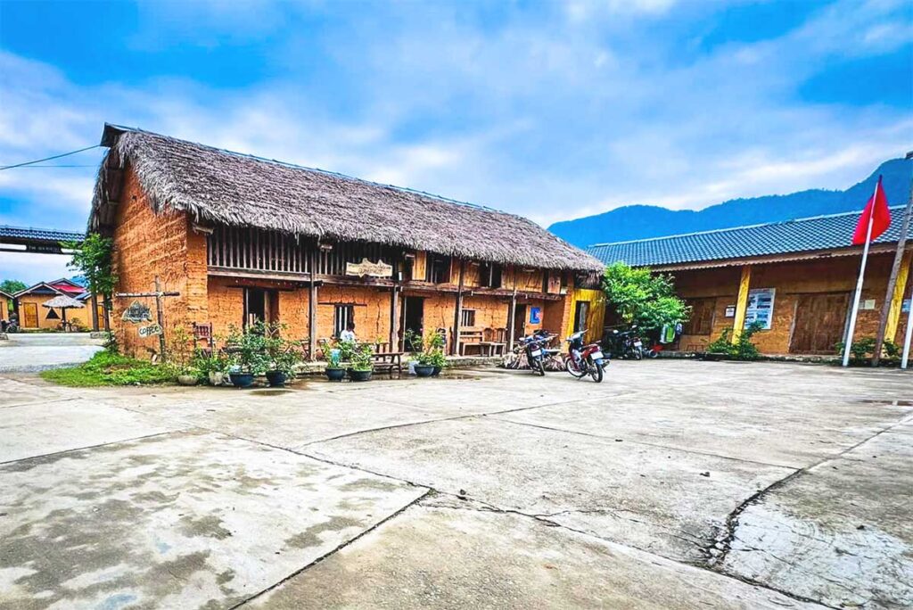 A traditional yellow clay ethnic house in Nam Dam Village, Ha Giang, with wooden doors and tiled roofs.