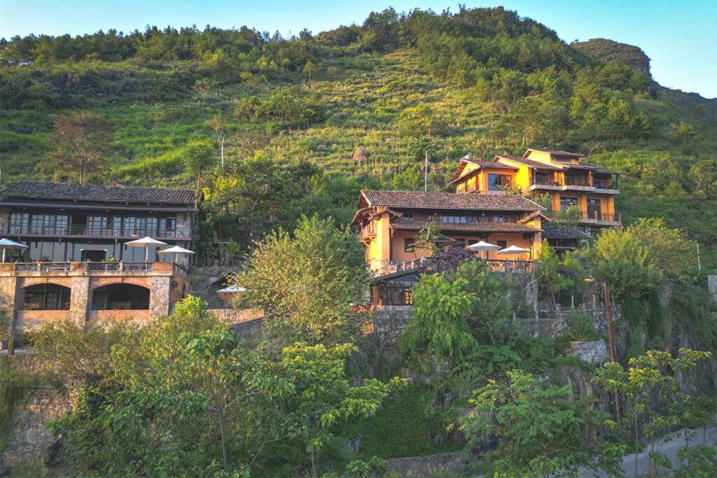 Several buildings of Tham Ma Retreat standing on top of the mountain