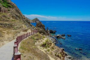 Eo Gió boardwalk with red railings curving along the rocky cliffs and turquoise sea in Quy Nhon, Vietnam