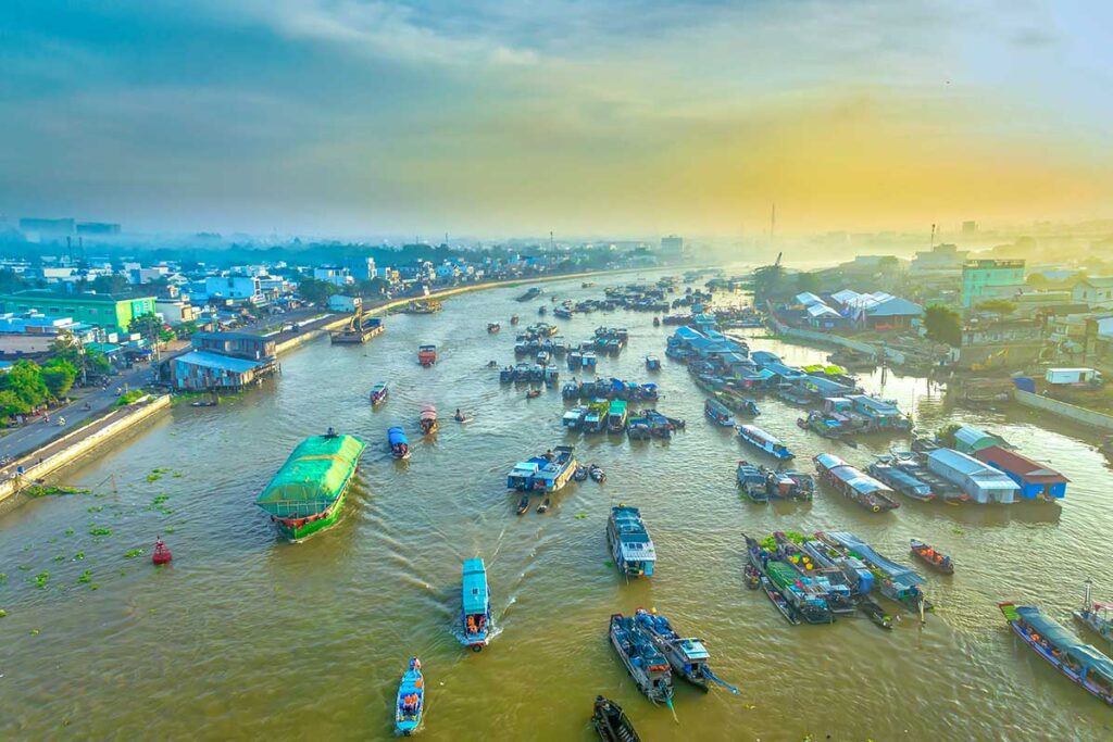 Aerial sunrise view of Cai Rang Floating Market showing dozens of trading boats clustered along the Hau River.