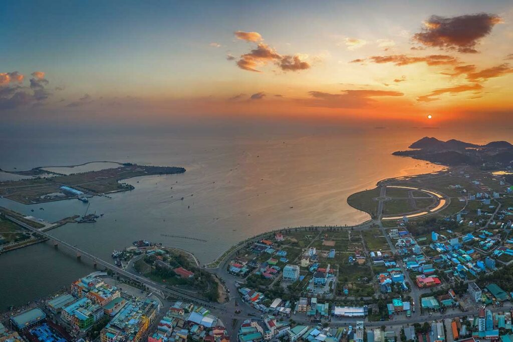 Aerial sunset view over Ha Tien town, coastline, and the Gulf of Thailand.