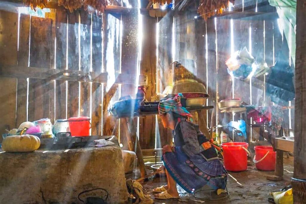 Ethnic woman in traditional clothes inside a traditional house in Khau Pa Commune