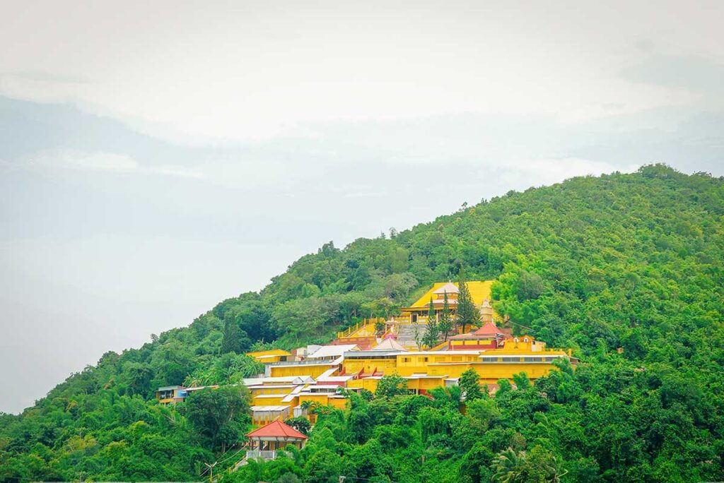 Bright yellow Ngoc Tien Monastery on a green hillside in Ha Tien.
