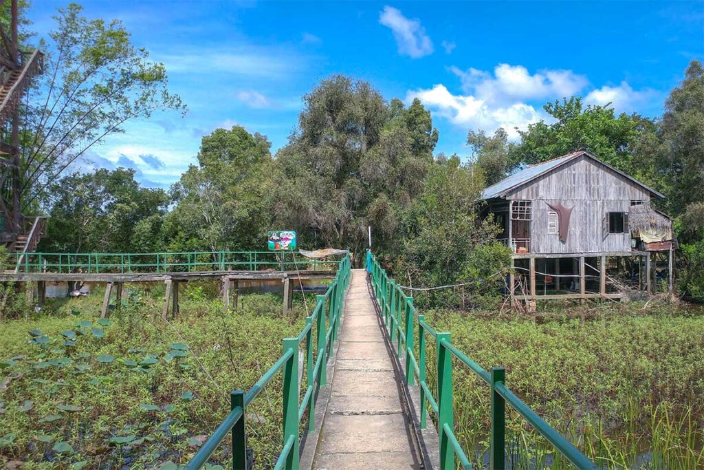 Wooden stilt house and walkway inside Tram Chim National Park, Dong Thap