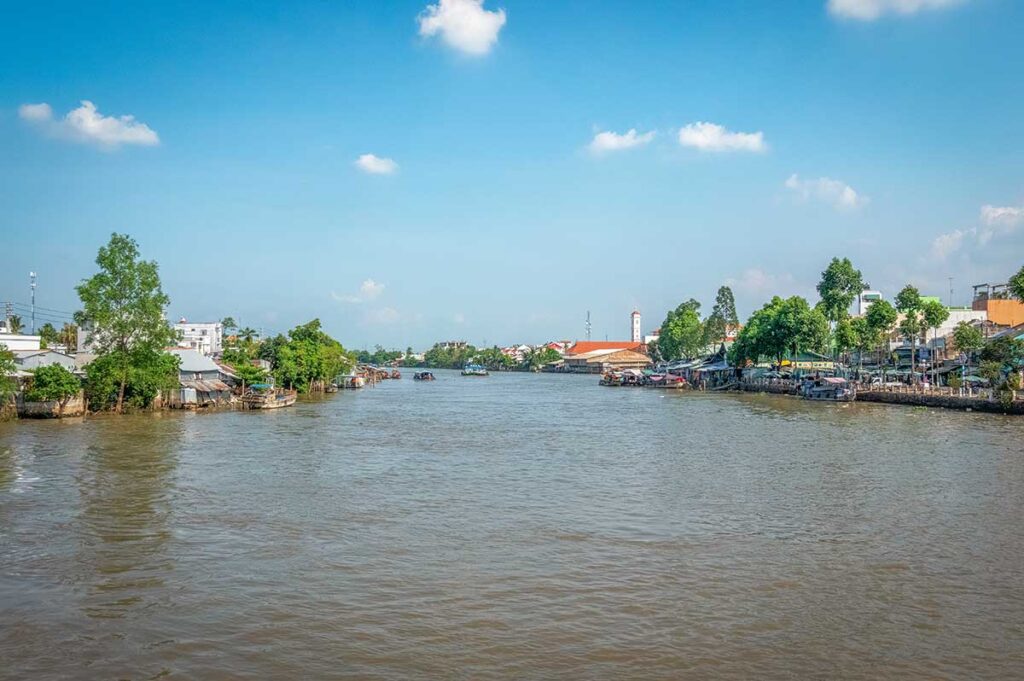 River view of Vinh Long in the Mekong Delta, showing local houses, greenery, and boats along the wide Hau River branch. vinh long market 2.jpg