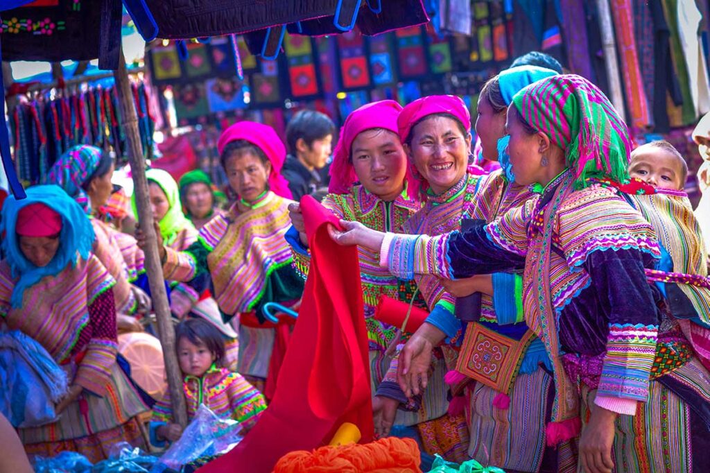 Colorful flower Hmong browsing clothes on the Bac Ha Market