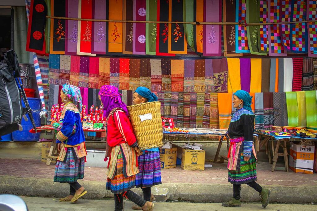 Ethnic minority woman walking in colorful traditional dresses over the Bac Ha Market