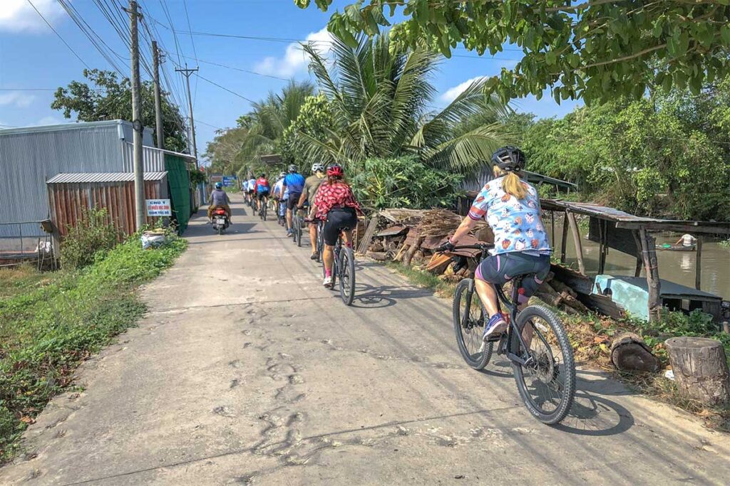 Cyclists on a countryside road near Bang Lang Stork Sanctuary, Mekong Delta Vietnam