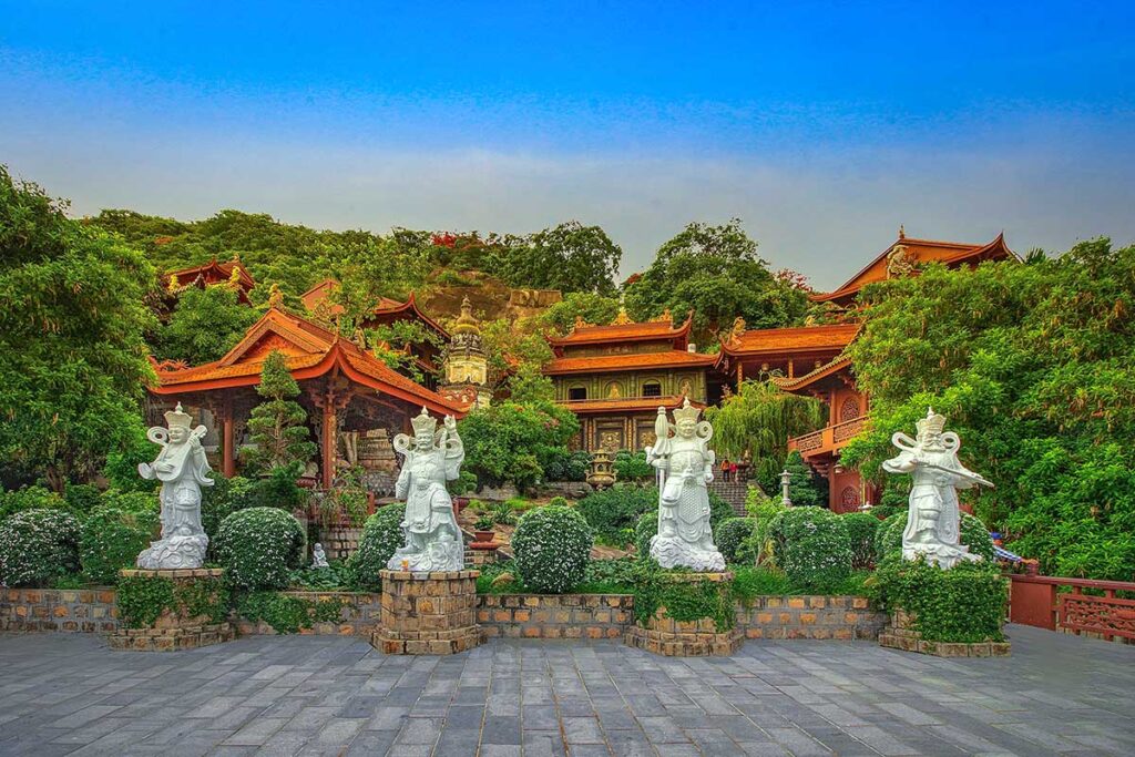 Hang Pagoda (Phuoc Dien Temple) on Sam Mountain in Chau Doc, with hillside shrines and guardian statues.