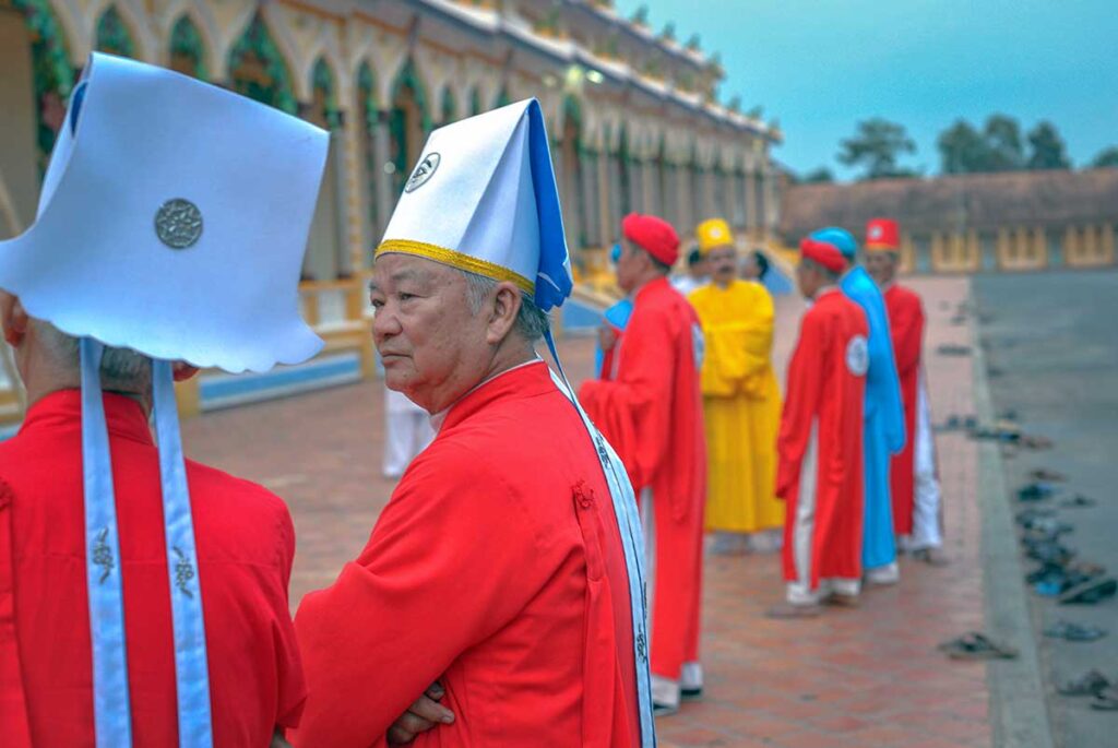 Priests in different color clothes waiting outside Tay Ninh Holy See before the daily prayers starts