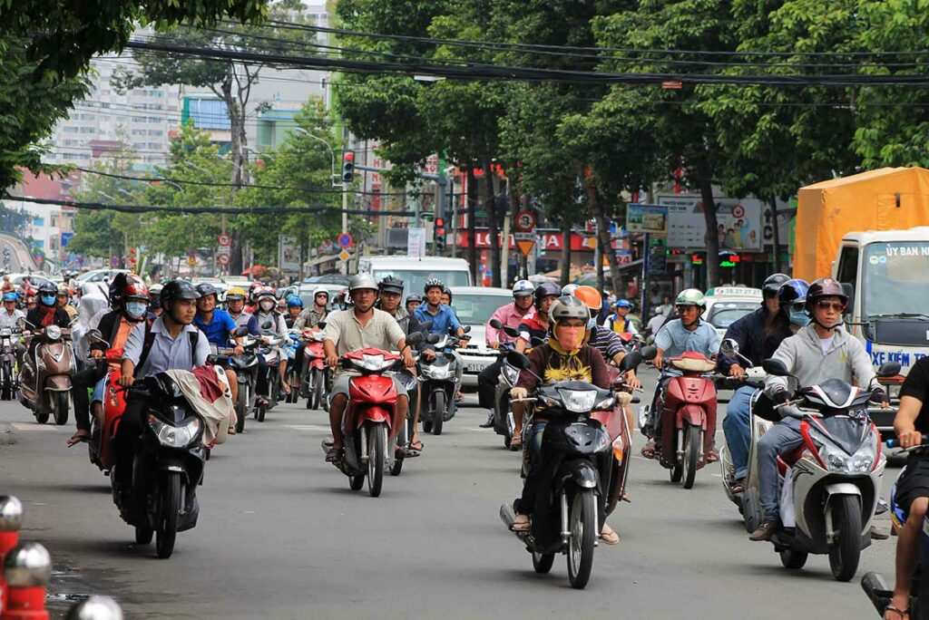 driving through busy traffic with lots of cars and motorbikes on the road in Vietnam