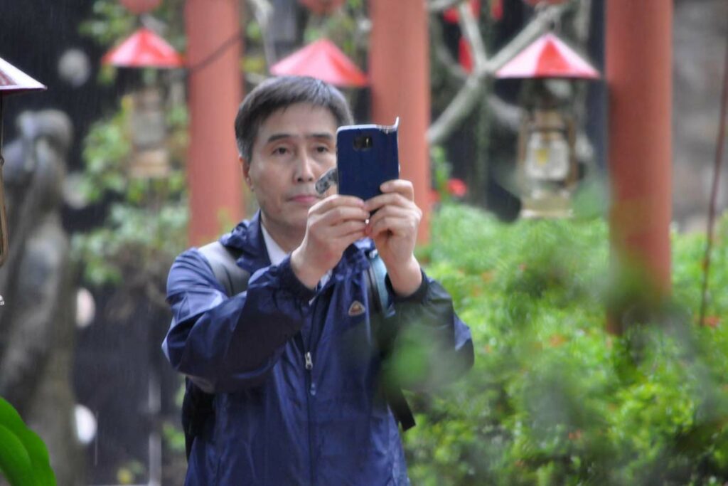 a tourist taking a photo with mobile on the street in Vietnam