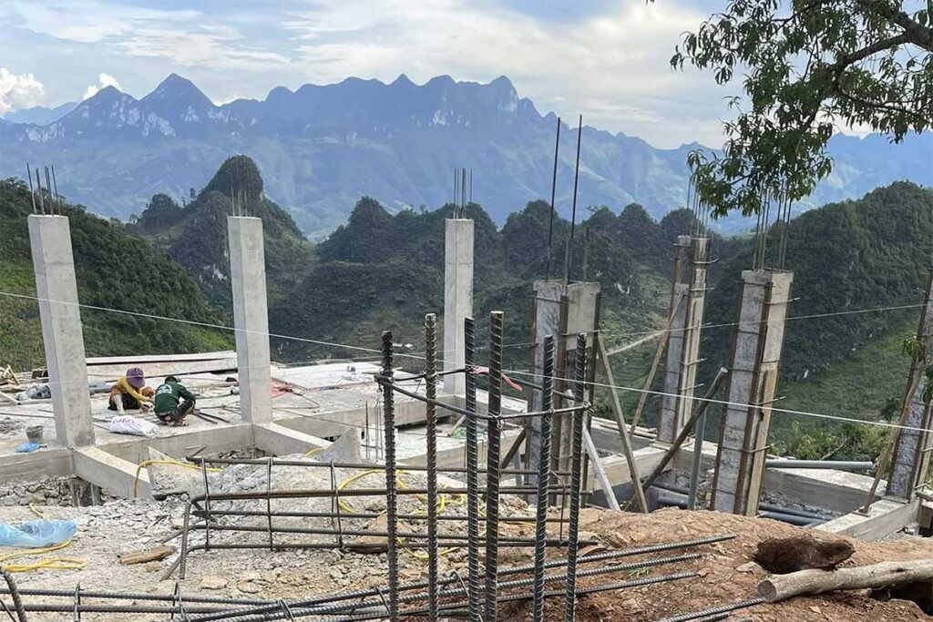 Foundation work for Local Vietnam’s first lodge in Ha Giang, with local builders working on a remote mountain site overlooking karst formations.