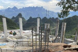 Foundation work for Local Vietnam’s first lodge in Ha Giang, with local builders working on a remote mountain site overlooking karst formations.