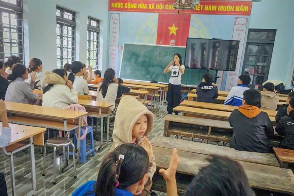 Duong Phung from Local Vietnam teaching English inside a classroom in Ha Giang, speaking to students during a lesson.
