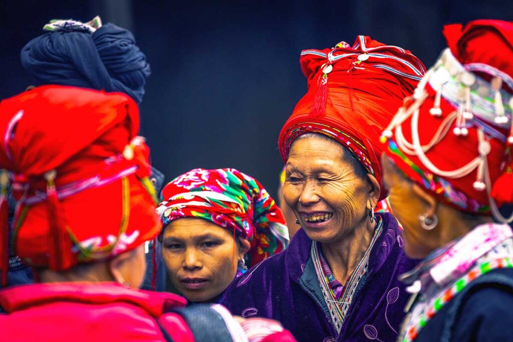 minority woman with red hats socializing on minorty woman shopping at Muong Hum Market