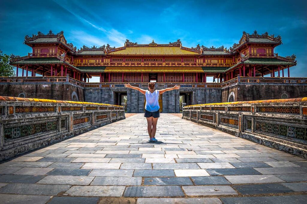 A young female backpacker at the gates of the imperial city of Hue, Vietnam.