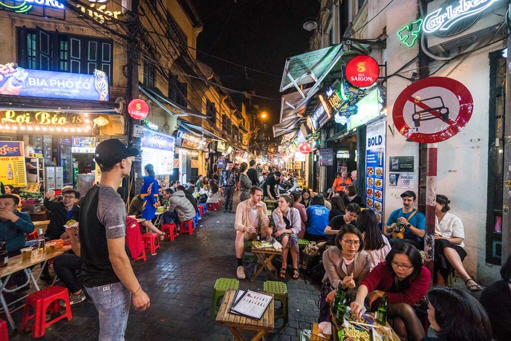 Backpackers drinking Bia Hoi in the streets of Hanoi Old Quarter