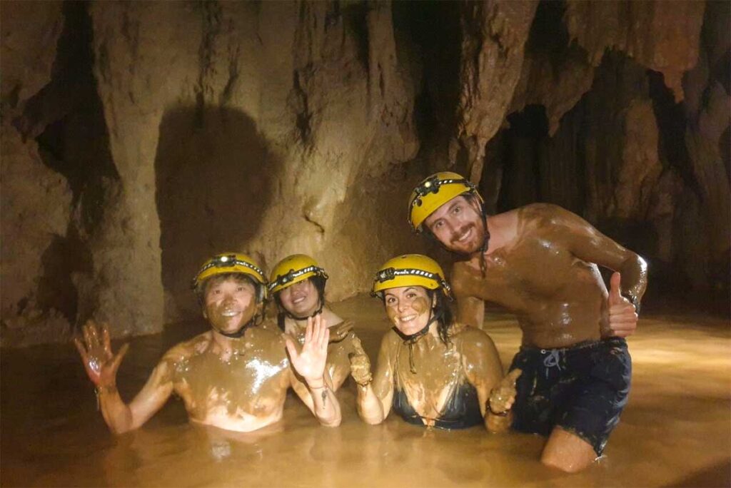 A group of backpackers in Vietnam are Dark Cave, part of Phong Nha completly covered in mud as the complete cave is made of mud