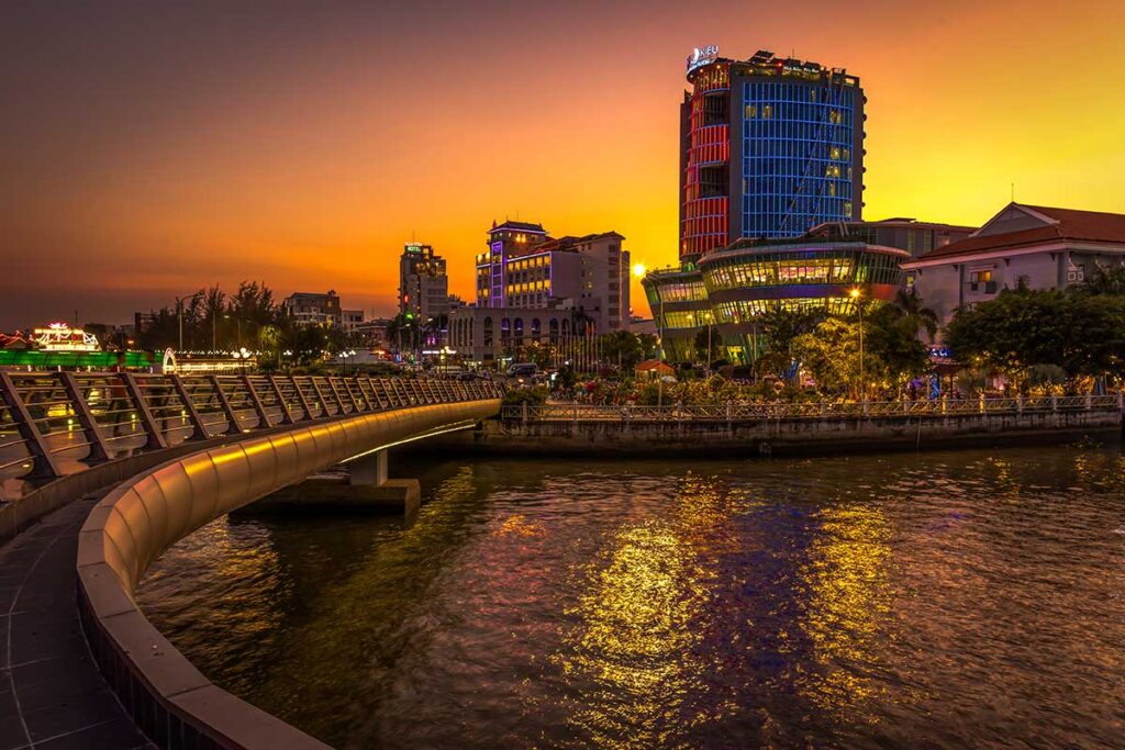 Ninh Kieu Wharf at Dawn: The golden light of dawn illuminates Ninh Kieu Wharf in Can Tho, casting a warm glow on the riverfront buildings.