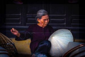 woman crafting traditional conical hats at Chuong Conical Hat Village near Hanoi