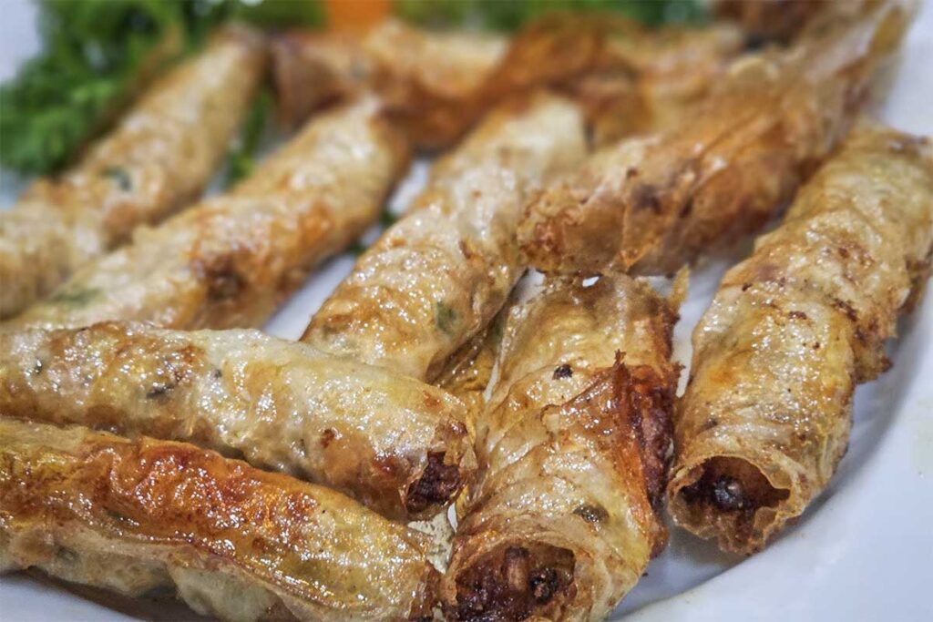 A plate of crispy Snake Spring Rolls, a unique culinary delicacy served at Hung Ha Noi Snake Restaurant in Le Mat Village.