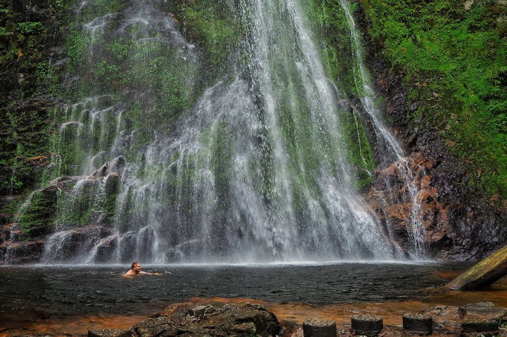 a man swimming in the pool of Love Waterfall in Sapa