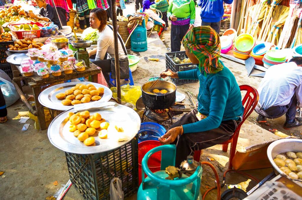 minority woman cooking food at the minorty woman shopping at Muong Hum Market