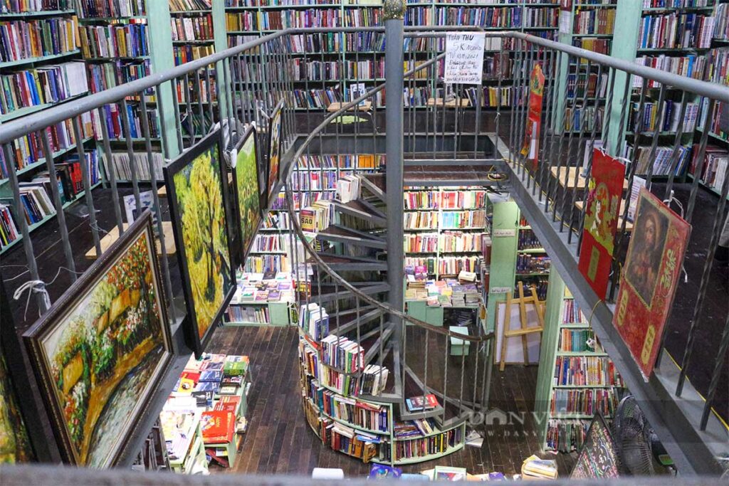 Nha Sach Moa Bookstore: Floor-to-ceiling bookshelves and a spiral staircase create a visually stunning Instagrammable backdrop at Nha Sach Moa bookstore in Hanoi.