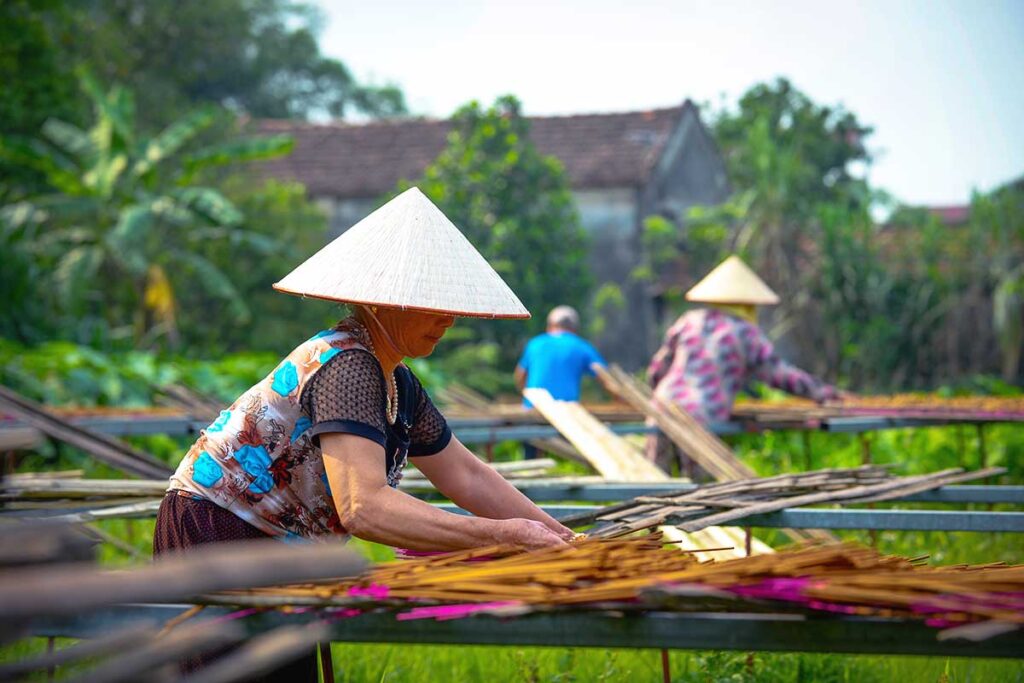 woman laying done incense sticks to dry at Quang Phu Cau Incense Village