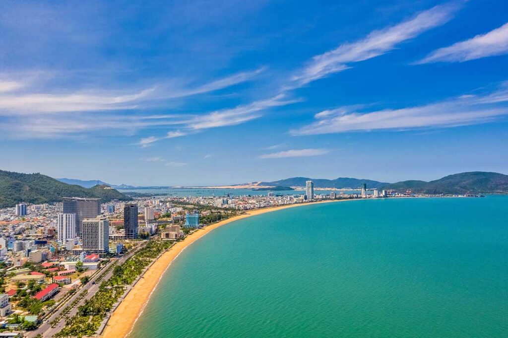 Quy Nhon Aerial View: An aerial view of Quy Nhon city reveals its expansive coastline with a pristine beach and the cityscape in the background.